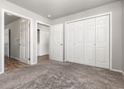 Thumbnail 22 of 26 - A room with white doors and a carpeted floor.