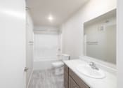 Thumbnail 8 of 26 - A white bathroom with a toilet, sink, and mirror.
