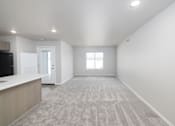 Thumbnail 4 of 26 - A spacious, empty room with a carpeted floor and a window.