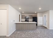 Thumbnail 3 of 26 - A kitchen with a white countertop and a black refrigerator.