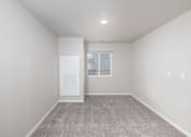 Thumbnail 19 of 26 - A room with a carpeted floor and a window with a balcony.