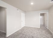 Thumbnail 25 of 26 - A spacious room with carpeted floor and white walls.