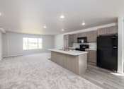Thumbnail 15 of 26 - A spacious kitchen with a black refrigerator and a microwave above the counter.