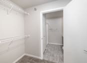 Thumbnail 24 of 26 - A white closet with a doorway leading to another room.