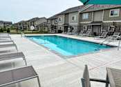 Thumbnail 30 of 37 - Sparkling blue pool surrounded by lounge chairs.