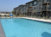 Thumbnail 17 of 20 - Sparkling blue pool surrounded by lounge chairs.