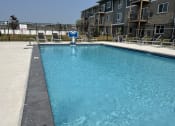 Thumbnail 16 of 20 - Sparkling blue pool surrounded by lounge chairs.