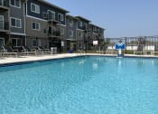 Thumbnail 18 of 20 - Sparkling blue pool surrounded by lounge chairs.