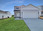 Thumbnail 3 of 59 - A house with a garage and a driveway in front of it.