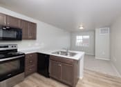 Thumbnail 1 of 22 - A kitchen with a stove, microwave, and sink.