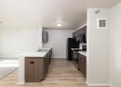 Thumbnail 9 of 22 - A kitchen with a white counter top and wooden cabinets.