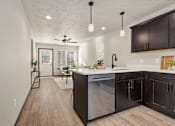 Thumbnail 5 of 43 - A modern kitchen with dark wood cabinets and a stainless steel dishwasher.