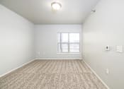 Thumbnail 5 of 26 - A room with a carpeted floor and a window.