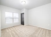Thumbnail 7 of 26 - A room with a carpeted floor and a door.