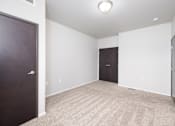 Thumbnail 13 of 26 - A room with a carpeted floor and two doors.
