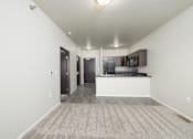 Thumbnail 14 of 26 - A spacious living room with a kitchen area in the background.
