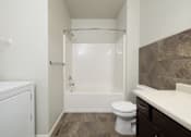 Thumbnail 20 of 26 - A white toilet sits next to a bathtub in a bathroom.