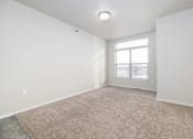 Thumbnail 26 of 26 - A room with a carpeted floor and a window.