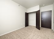 Thumbnail 9 of 26 - A room with a carpeted floor and a black door.