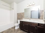 Thumbnail 8 of 26 - A bathroom with a white toilet and a white sink.