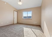 Thumbnail 49 of 64 - A room with a carpeted floor, a window, and a door.