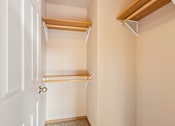 Thumbnail 52 of 64 - A white door with a gold handle is on the left and a shelf is on the right.