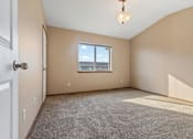 Thumbnail 50 of 64 - A room with a carpeted floor, a window, and a door.