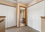 Thumbnail 55 of 64 - A hallway with white doors and a carpeted floor.