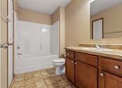 Thumbnail 56 of 64 - A bathroom with a toilet, sink, and bathtub.