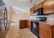Thumbnail 11 of 64 - A kitchen with black appliances and wooden cabinets.