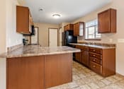 Thumbnail 20 of 64 - A kitchen with brown cabinets and a granite counter top.