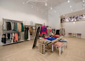 Thumbnail 40 of 41 - A clothing store with a variety of clothes on display.