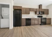 Thumbnail 1 of 32 - A kitchen with brown cabinets and black appliances.
