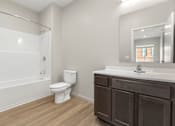 Thumbnail 4 of 32 - A white toilet sits in a bathroom next to a sink.