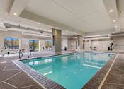 Thumbnail 8 of 54 - A large indoor swimming pool with a tiled floor and walls.