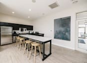 Thumbnail 25 of 33 - a kitchen with a long island with bar stools and a stainless steel refrigerator