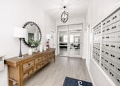 Thumbnail 27 of 33 - a hallway with a dresser and a mirror in a white room