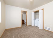 Thumbnail 15 of 22 - A room with a white fridge and a brown carpet.