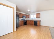 Thumbnail 4 of 22 - A kitchen with wooden cabinets and a black fridge.