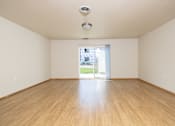 Thumbnail 12 of 22 - A room with wooden floors and a window showing a street view.