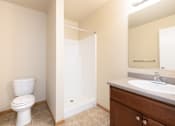 Thumbnail 9 of 22 - A white toilet is in a bathroom with a sink and mirror.