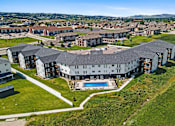 Thumbnail 42 of 44 - A large building with a pool in the middle of a grassy area.