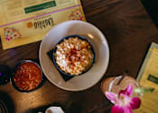 Thumbnail 36 of 41 - A dessert dish with a sprinkle of cinnamon on top is served on a white plate.