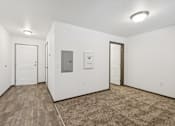 Thumbnail 21 of 21 - A room with a white wall and a brown carpet.