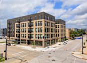 Thumbnail 42 of 42 - A large building with many windows is situated on a street corner.