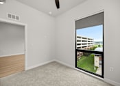 Thumbnail 33 of 42 - A room with a window that has a view of a building and a lawn outside.