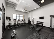 Thumbnail 10 of 42 - A black and white photo of a gym with various exercise equipment.