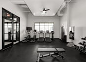 Thumbnail 18 of 42 - A black and white photo of a gym with a variety of equipment.
