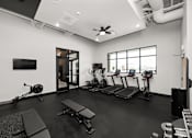 Thumbnail 19 of 42 - A gym with a variety of equipment including treadmills, exercise bikes, and weightlifting machines.