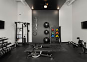 Thumbnail 20 of 42 - A black and white photo of a gym with a variety of equipment.